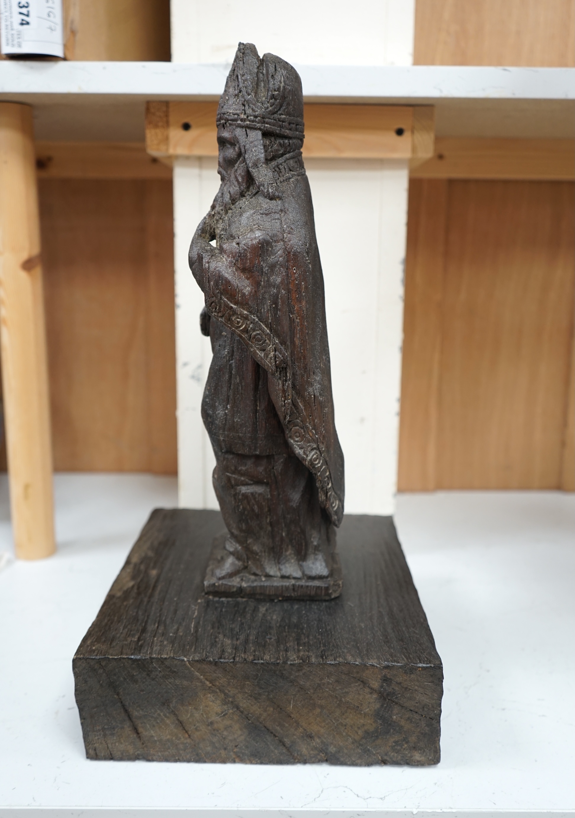 A North European oak carving of a bishop, possibly 17th/18th century, 38cm high not including stand. Condition - poor